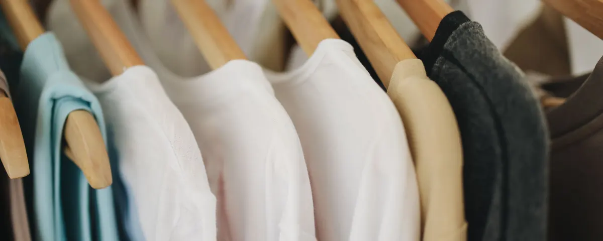 Tee-shirts unis suspendus à des cintres en bois